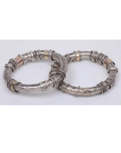 Two silver and gold bangles in tubular form with loose ring decoration..
