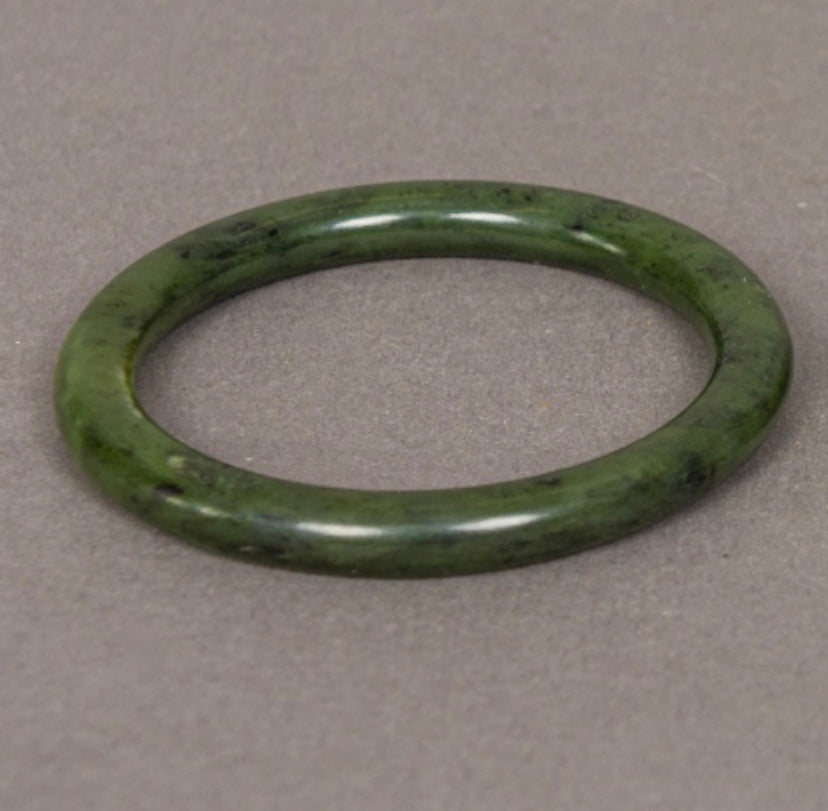 Chinese spinach jade bangle of plain tubular form..