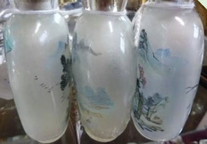 Three Chinese internally painted glass snuff bottles, each decorated with landscapes.