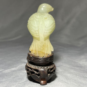 A CHINESE JADE BIRD ON ROSEWOOD STAND, QING DYNASTY (1644-1911)